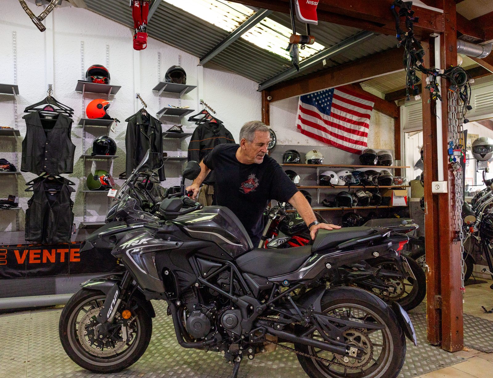 Dans l’agence, une Benelli TRK devant le rayon des casques