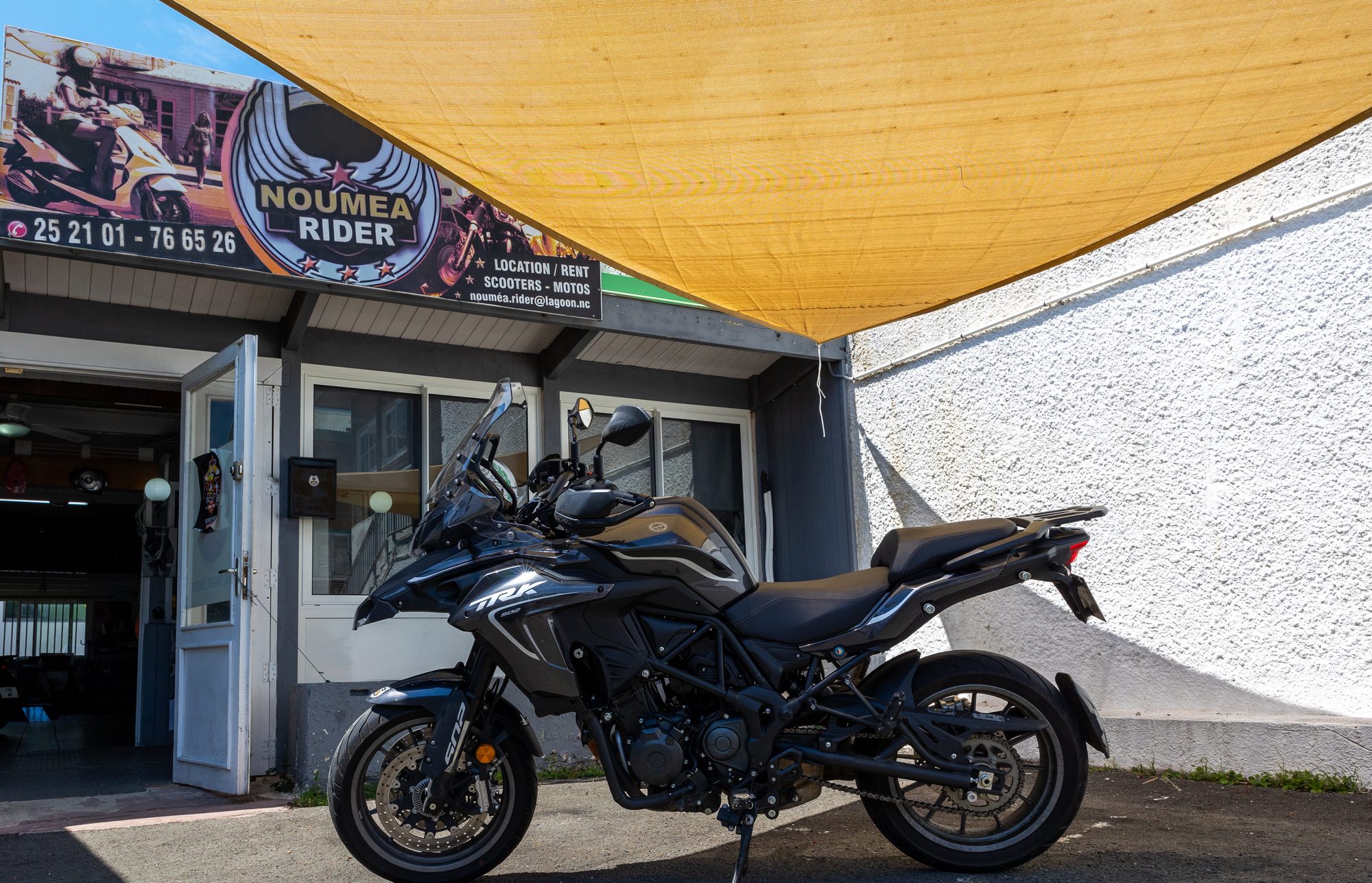 Une moto Benelli TRK devant l’agence Nouméa Rider, sous son enseigne